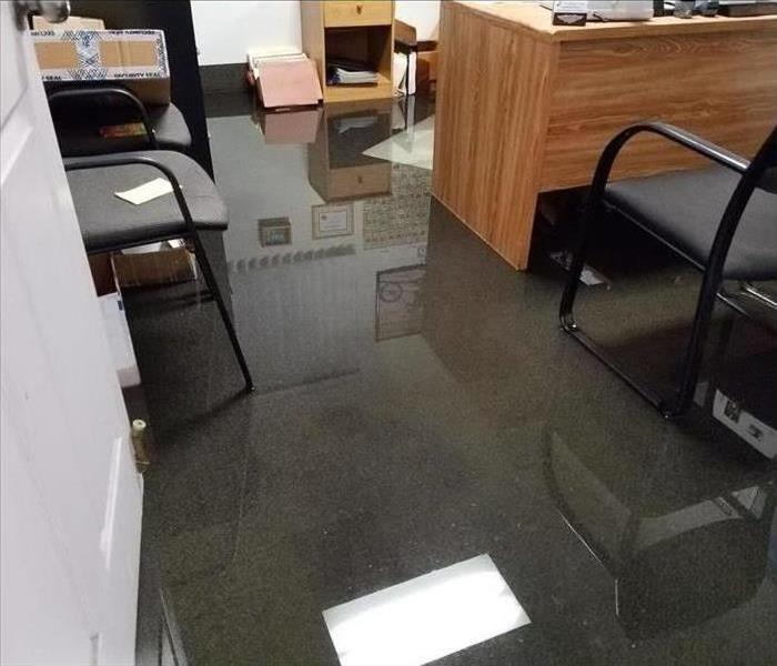 Office with desks and chairs sitting in water damage