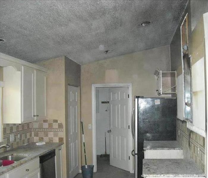 kitchen with tan walls and white ceiling covered in soot damage