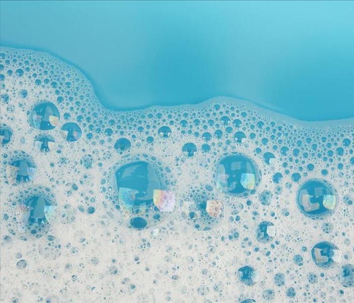 Soapy bubbles on blue surface.